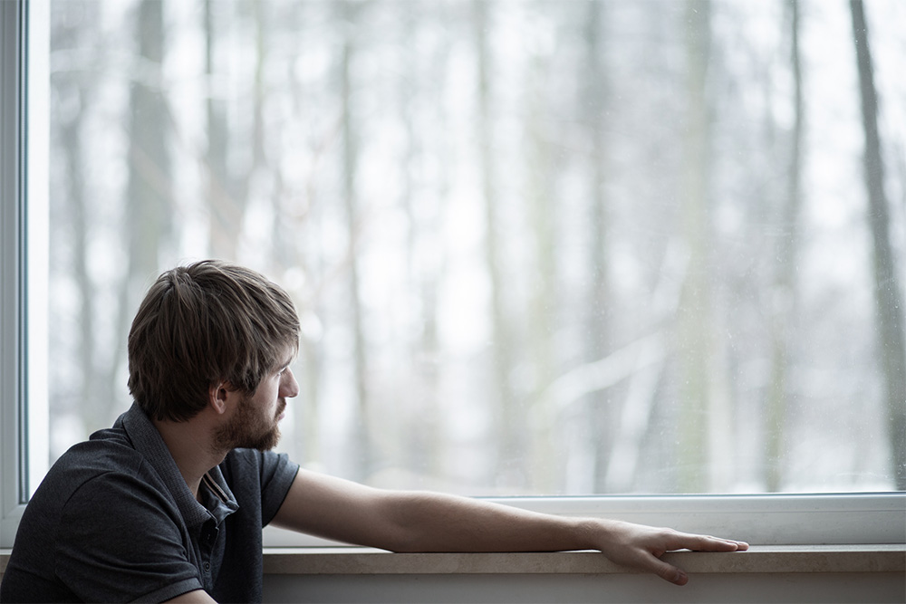 Man who is feeling depressed and is looking out of the window